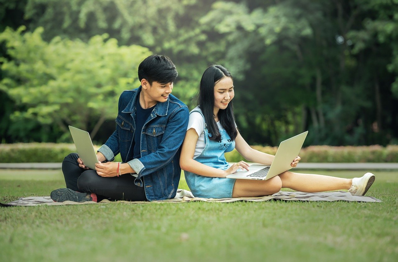 adolescents avec ordinateurs portables dans un parc
