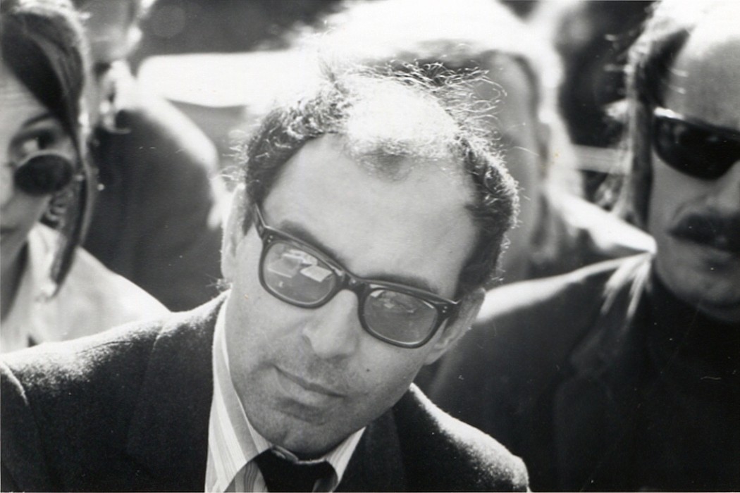 photo en noir et blanc du visage de Jean-Luc Godard avec lunettes de soleil