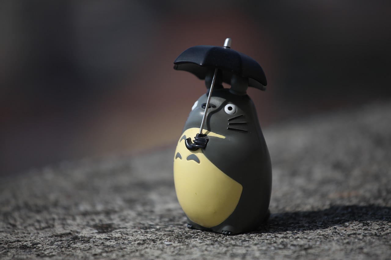 figurine du personnage de Totoro qui ressemble à une chouette, de couleur noire, avec un parapluie noir au-dessus de la tête