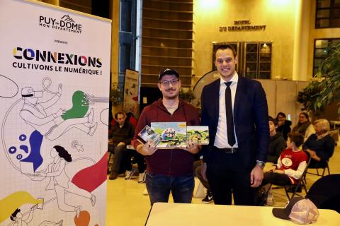 le gagnant du concours de jeu vidé pose avec le vice-président du Département