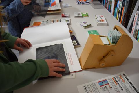 mains d'enfant manipulant une grille quadrillée sur un livre