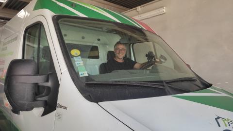 Capot et pare brise d'une camionnette avec bandes vertes avec tête d'homme avec lunettes au volant dans un garage