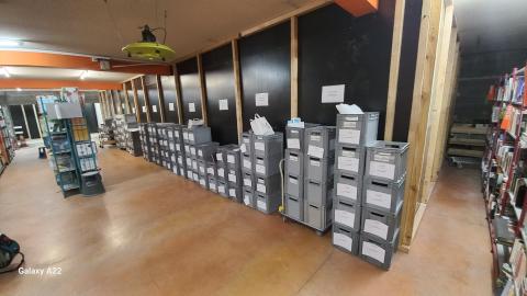 caisses de sélections stockées le long d'une palissage de chantier