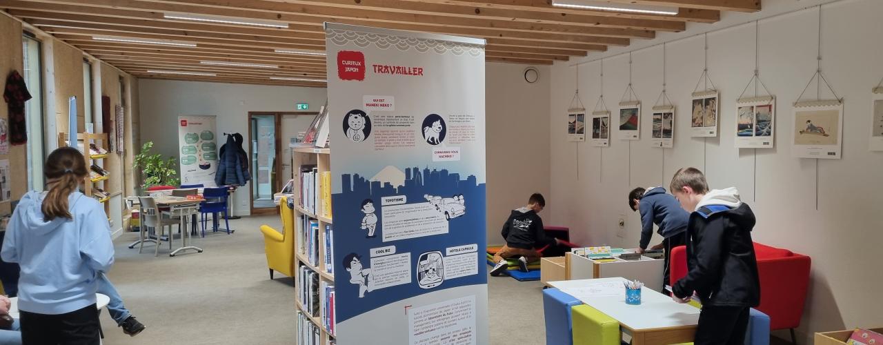 espace bibliothèque avec tables et panneau et enfants