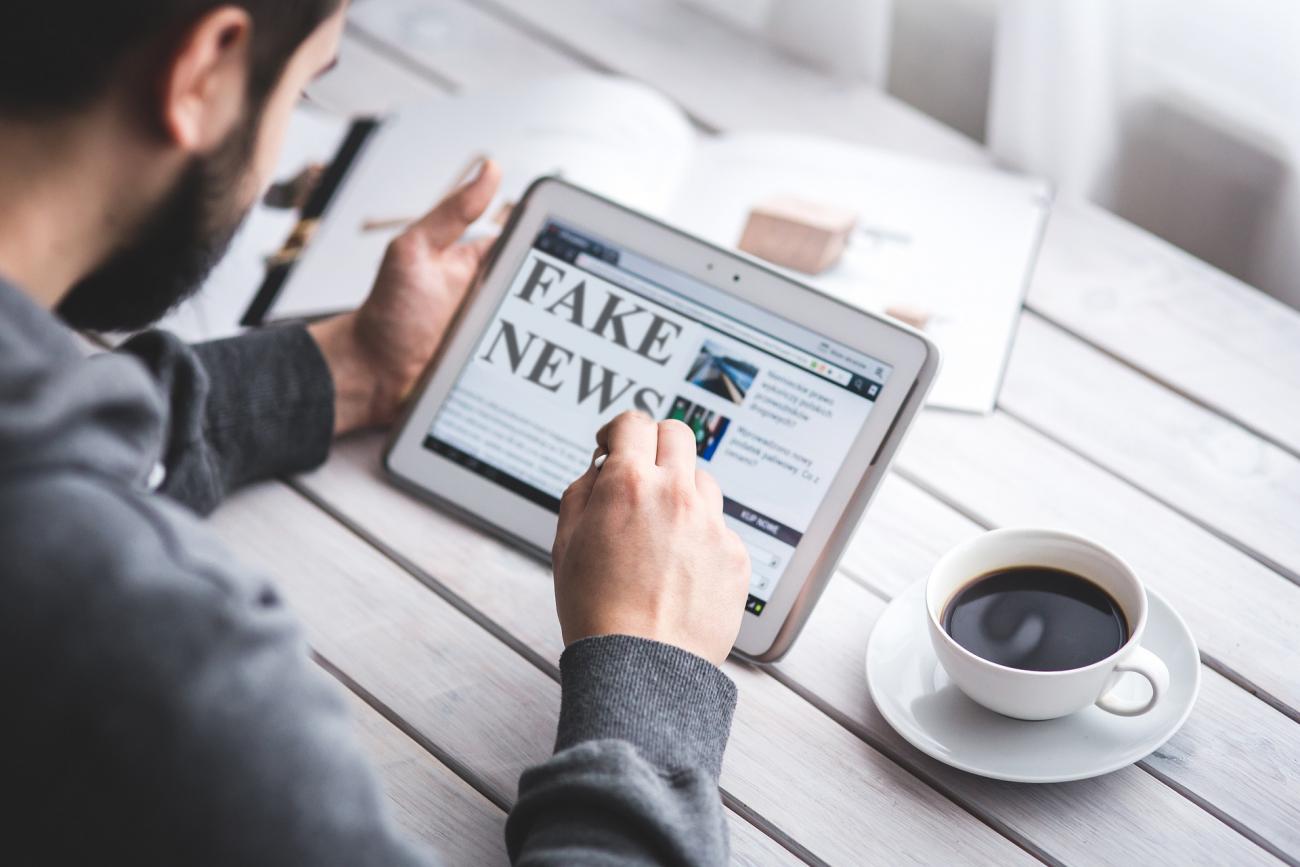 Homme regardant un site &quot;Fake news&quot; sur tablette
