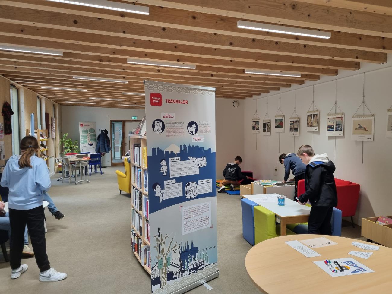 espace bibliothèque avec tables et panneau et enfants