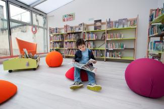 Photo enfant en train de lire à la bibliothèque