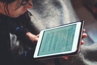 femme lisant sur une tablette un livre numérique