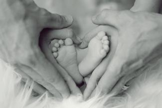 Pieds de bébé entourés des mains de ses parents