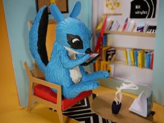 sculpture écureuil bleu lisant assis sur une chaise