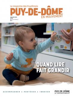 Couverture du magazine avec un bébé qui tient un livre