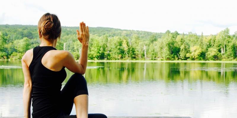 Femme yoga devant un lac