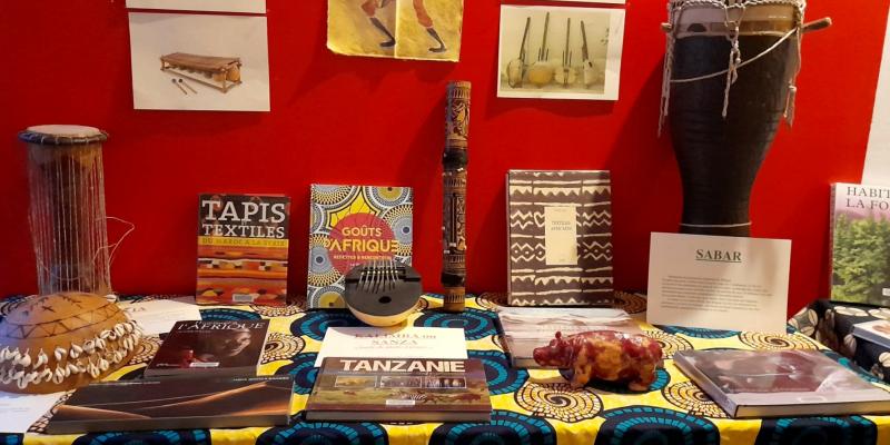 Des instruments de musique africains et des livres sur une table joliment décorée de tissus africains