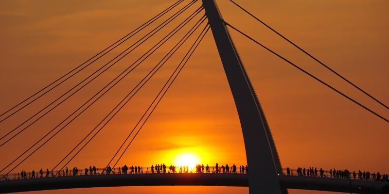 Pont avec des gens dessus sur fond de coucher de soleil